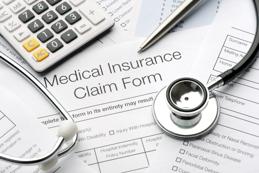 A close up of a medical insurance form with a stethoscope laid out on a table.