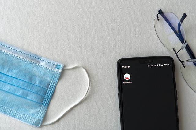 A picture of a mask, phone and glasses in the workplace.